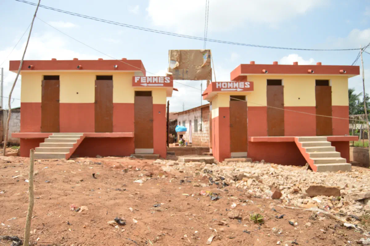 Les deux blocs de toilettes ECOSAN achevés à la gare routière de Sèhouè, signalés « Femmes » et « Hommes »