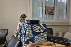 Les intervenants au micro. Au mur, une tenture en appliqué figurant le continent africain.